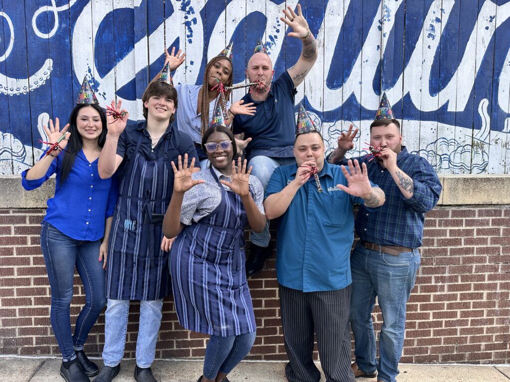 Saltine staff striking celebratory poses for restaurant's 10th birthday